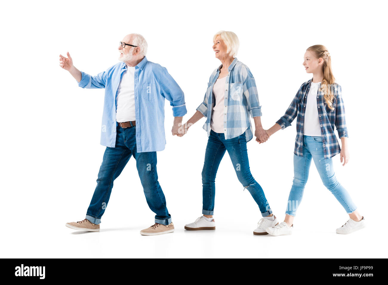 Heureux grand-père, la grand-mère et petite-fille de marcher et tenir la main ensemble isolated on white Banque D'Images
