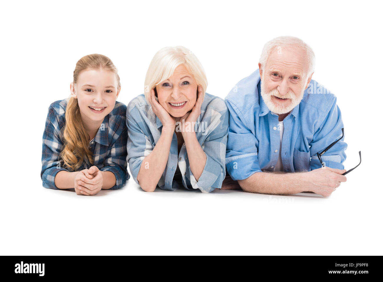 Grand-père, la grand-mère et petite-fille lying together isolated on white Banque D'Images