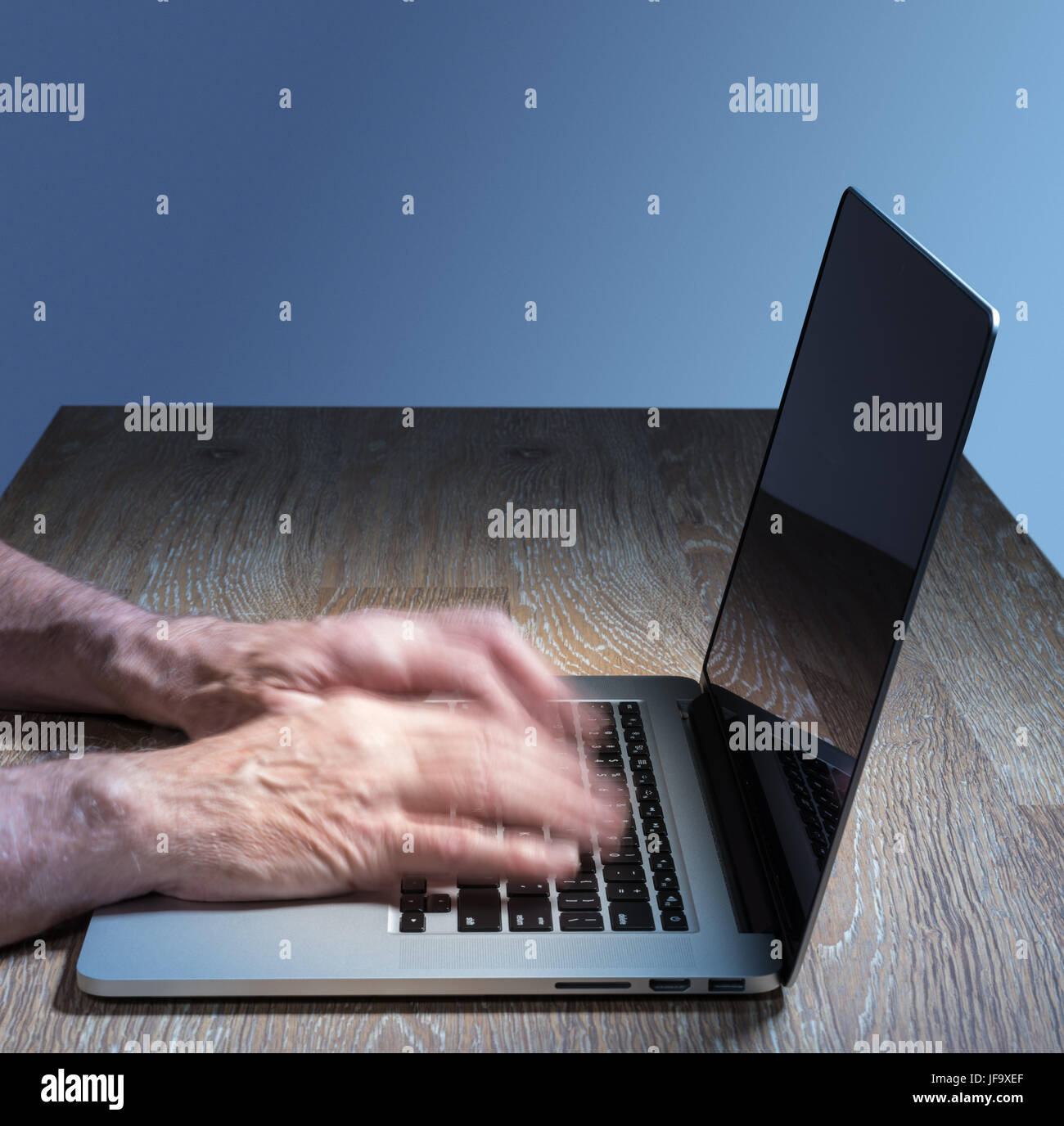 Senior adult man touch types on laptop Banque D'Images