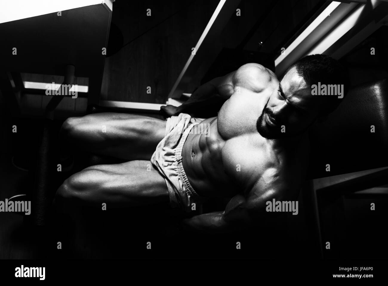 L'homme l'exercice de jambe avec la machine dans la salle de sport - Jambes Close Up Banque D'Images
