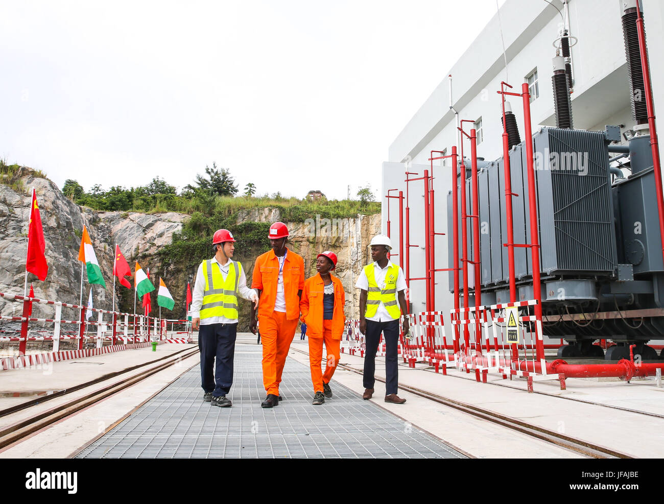 (170630) -- SOUBRE (CÔTE D'IVOIRE), le 30 juin 2017 (Xinhua) - Wang- Guanguan (1re L), un technicien chinois, promenades avec sa côte d'Ivoire, ses collègues de l'Soubre station d'énergie hydroélectrique près de la ville de Soubre en Côte d'Ivoire, le 30 juin 2017. Une cérémonie a eu lieu vendredi en Côte d'Ivoire pour marquer officiellement le début de la production d'électricité à Soubre centrale hydroélectrique, qui a été construit par une société chinoise. Avec une capacité installée de 275 MW, le 4,5 km de long barrage Soubre est la plus grande de ce genre jusqu'à présent dans le pays d'Afrique de l'ouest. (Xinhua/Pan François Picard) Banque D'Images