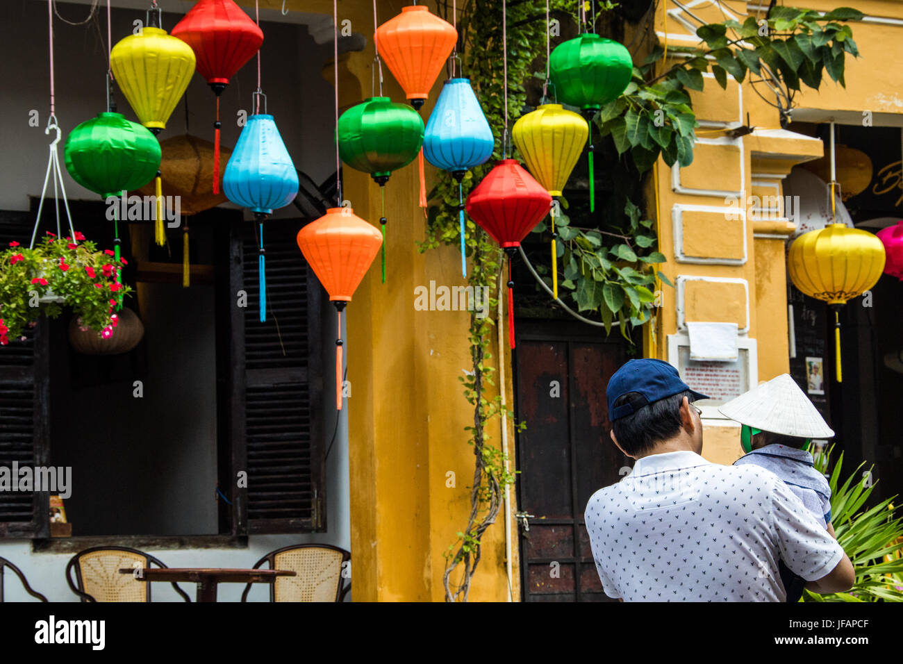 Tourisme chinois et son jeune fils à pied entre les lanternes traditionnelles à Hoi An, Vietnam Banque D'Images