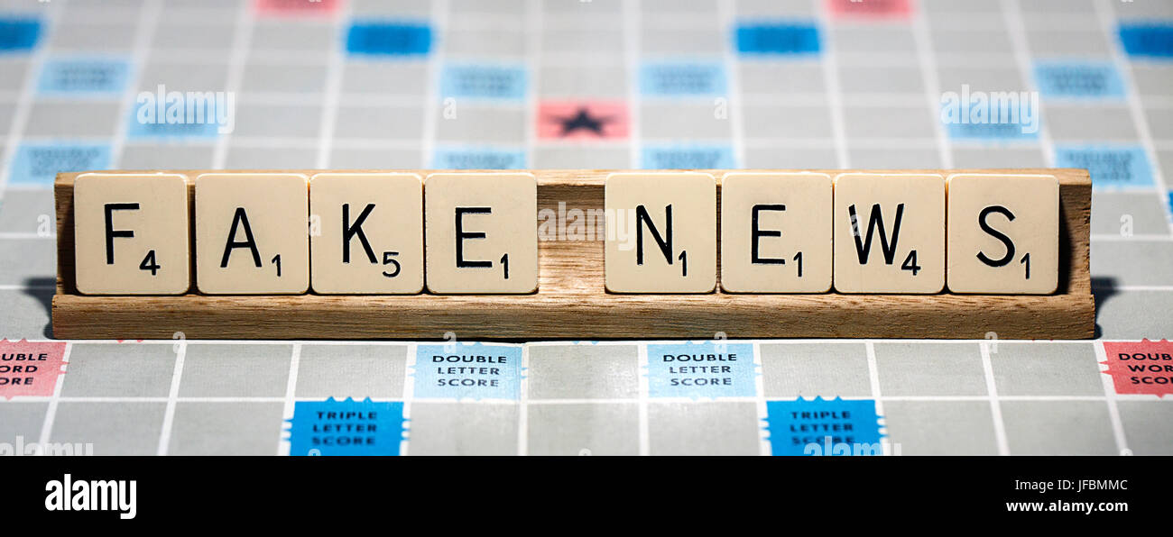 Une partie de Scrabble avec les lettres formant les mots 'Fausse News'. Le Scrabble est un jeu amusant et éducatif distribué dans le monde entier par Hasbro. Banque D'Images