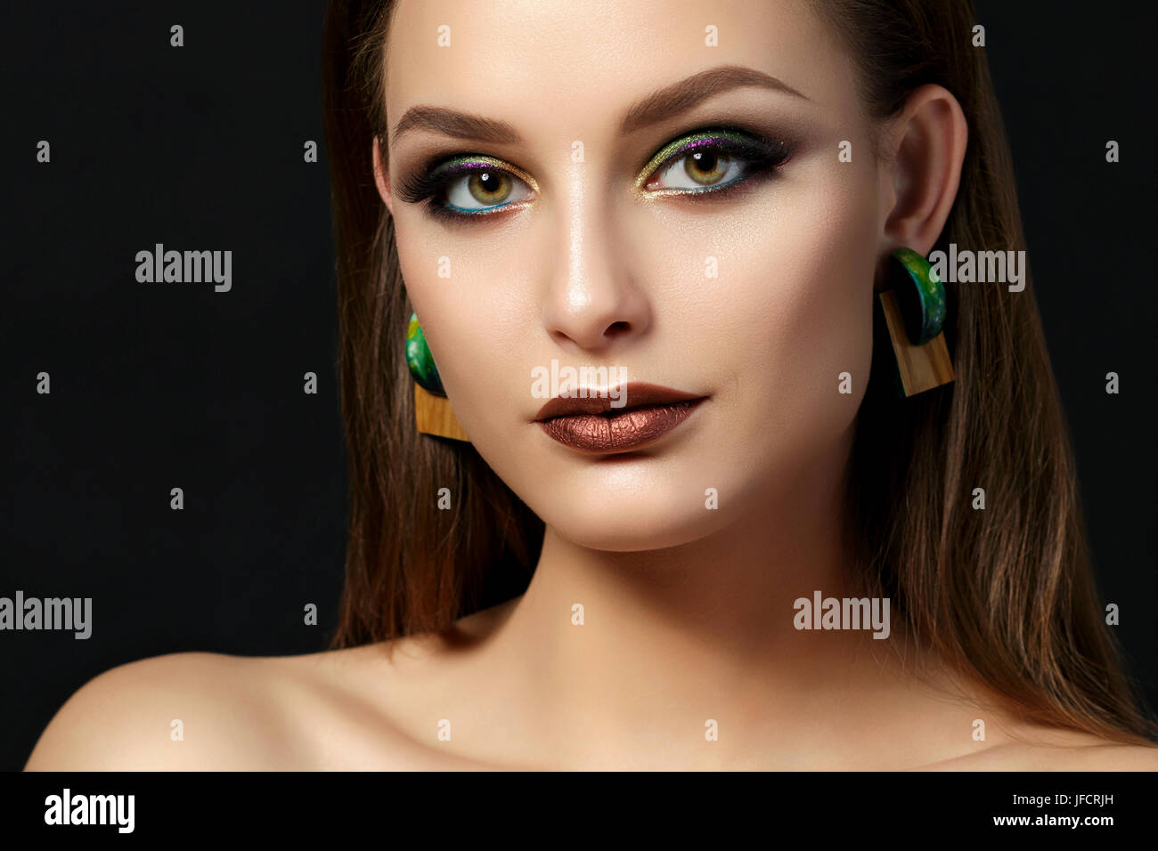 Close up portrait of young woman with brown lèvres et yeux smoky vert sur fond noir. Sourcils parfaits. La mode moderne. Studio shot Banque D'Images