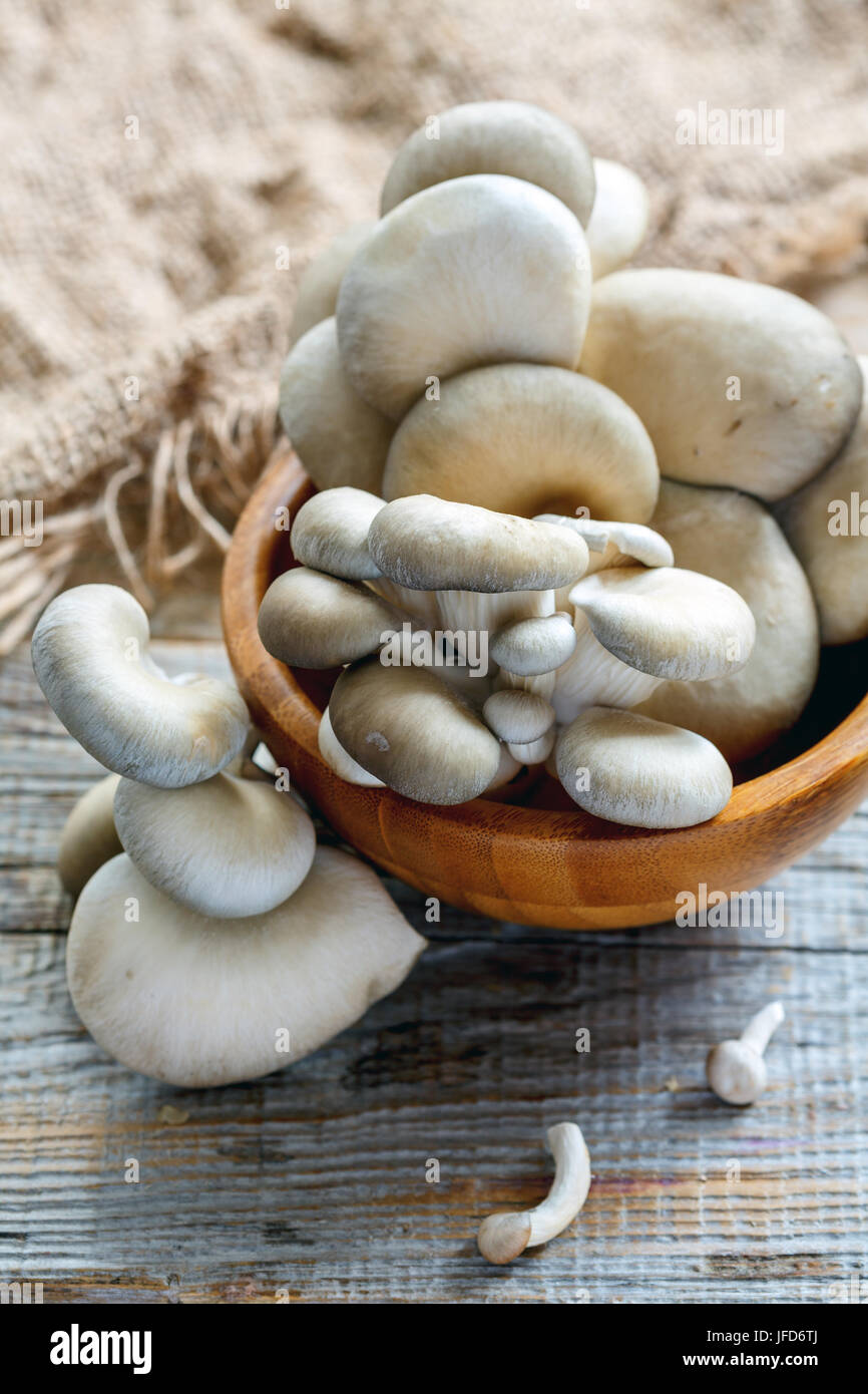 Pleurotes frais dans un bol en bois. Banque D'Images