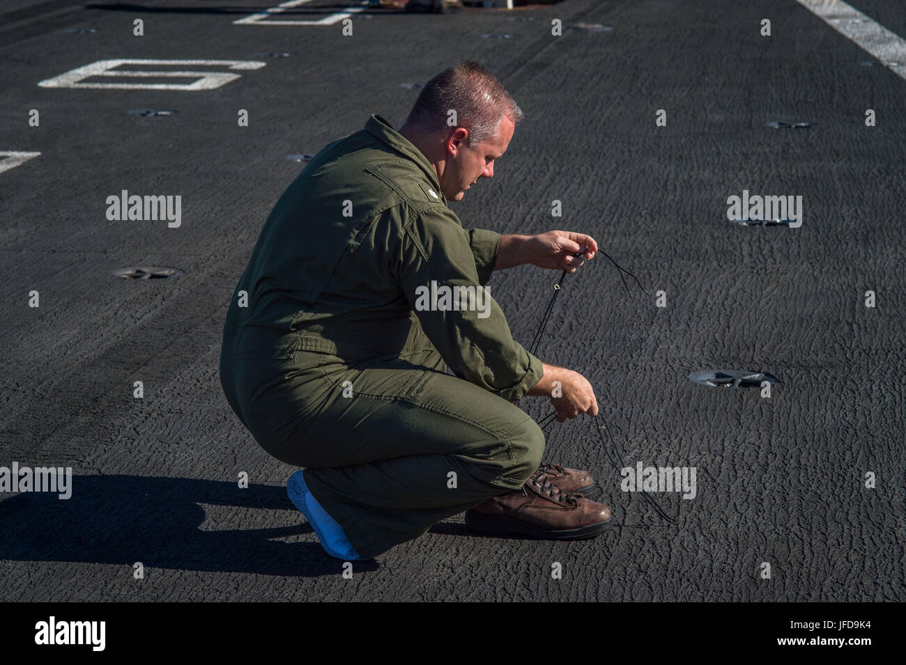 1706627-N-AZ808-105 OCÉAN PACIFIQUE (27 juin 2017) - Le Cmdr. Dennis Metz, le mini-boss à bord du porte-avions USS Theodore Roosevelt (CVN 71) se prépare pour un tournage d'amorçage sur le poste de pilotage. Les pousses de démarrage sont une tradition maritime dans laquelle une cérémonie a lieu pour le tireur au départ par le lancement d'une paire de bottes hors du navire par catapulte. Theodore Roosevelt est actuellement en cours au large de la côte de Californie du Sud. (U.S. Photo par marine Spécialiste de la communication de masse/Burgains Nicholas marin libéré) Banque D'Images