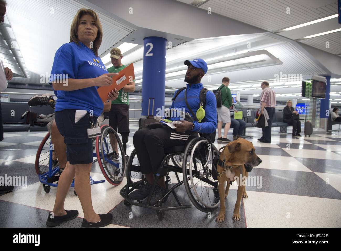 CHICAGO (28 juin 2017) une aide bénévole de United Airlines le s athlètes Jeux de guerrier. Anthony Pearson son chien Rocky après son arrivée à l'aéroport international O'Hare pour le ministère de la Défense 2017 Jeux de guerrier. La DoD Warrior Jeux sont un événement annuel permettant aux blessés, malades et blessés militaires et anciens combattants à la concurrence dans les sports paralympiques-style dont le tir à l'arc, randonnée à vélo, terrain, tir, le volleyball assis, natation, athlétisme et de basket-ball en fauteuil roulant. (Photo du département de la communication de masse en 2e classe spécialiste Anthony Presley) Banque D'Images