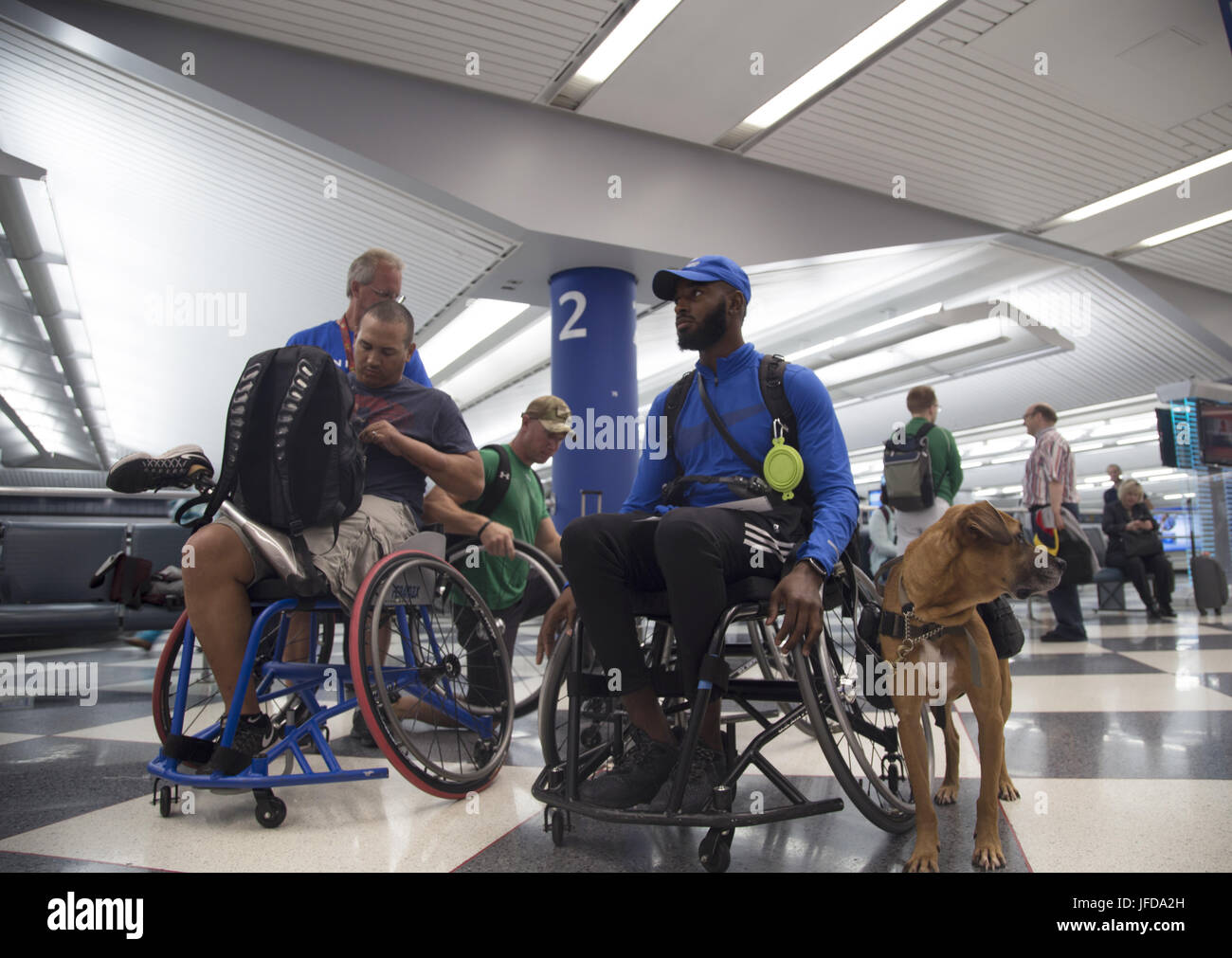 CHICAGO (28 juin 2017) De gauche à droite, les athlètes des Jeux de guerrier Master Sgt. Brian Williams, le sergent-chef. Bejamin Seekel, et le sergent. Anthony Pearson avec son chien Rocky sont assistés par des bénévoles de United Airlines après son arrivée à l'aéroport international O'Hare pour le ministère de la Défense 2017 Jeux de guerrier. La DoD Warrior Jeux sont un événement annuel permettant aux blessés, malades et blessés militaires et anciens combattants à la concurrence dans les sports paralympiques-style dont le tir à l'arc, randonnée à vélo, terrain, tir, le volleyball assis, natation, athlétisme et de basket-ball en fauteuil roulant. (DoD photo par la communication de masse spec Banque D'Images