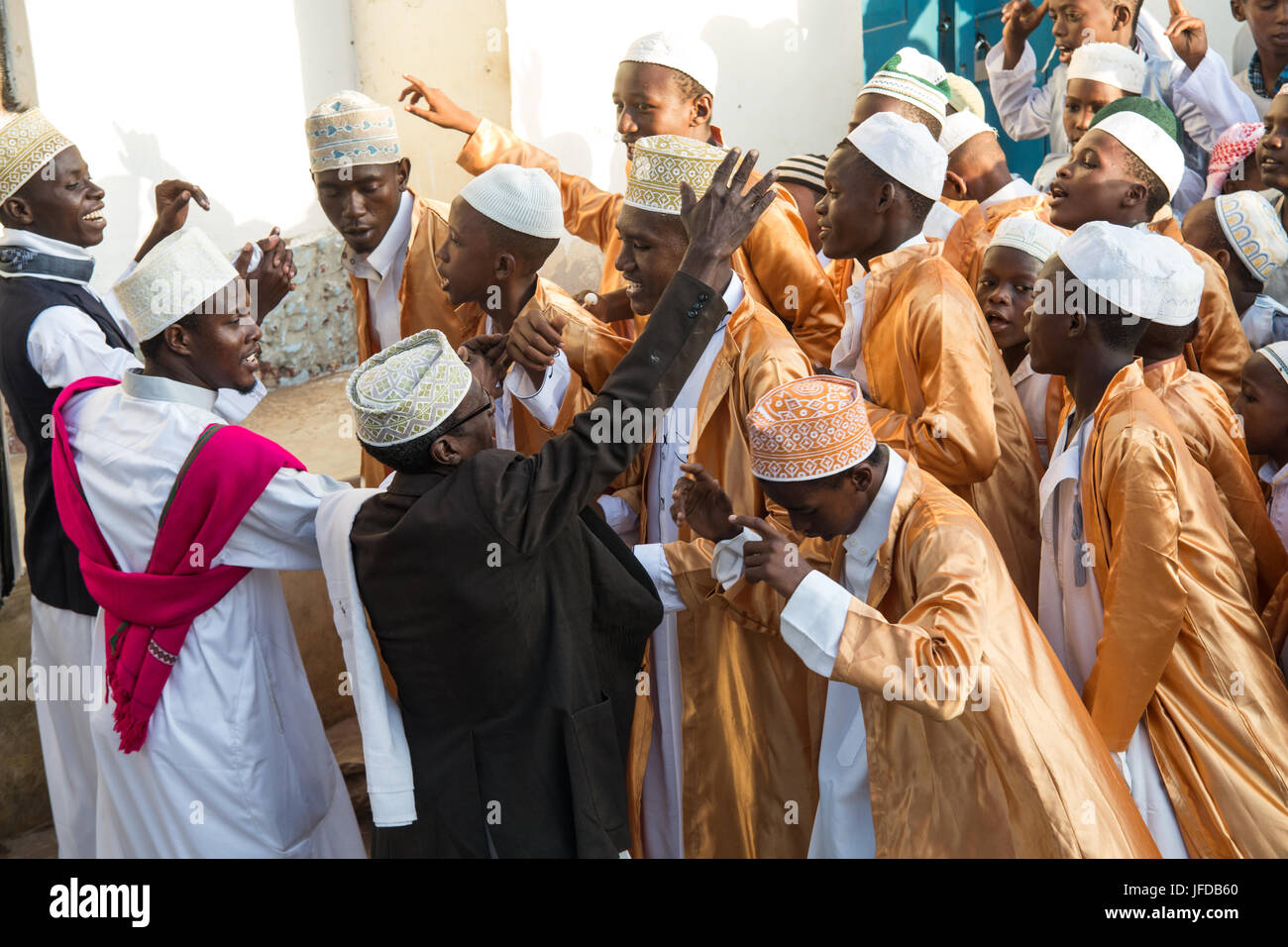 Des groupes d'hommes et de garçons célébrer l'Zefe procession le long des rues étroites de la vieille ville de Lamu au cours de l'Maulidi festival, Kenya, Africa Banque D'Images