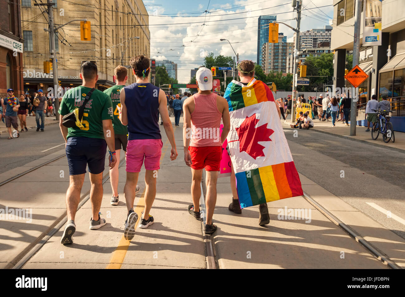 Toronto, CA - 25 juin 2017 : vue arrière d'un groupe de cinq jeunes hommes marchant sur la rue de l'église après Pride Parade. Banque D'Images