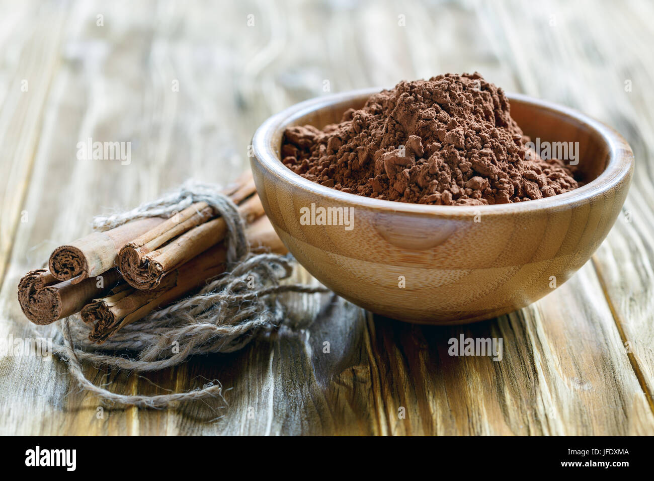 La poudre de cacao dans un bol en bois. Banque D'Images