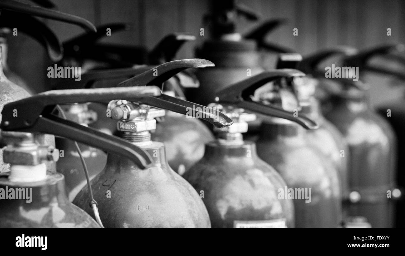 Image en noir et blanc des extincteurs prêts à être utilisés à l'exercice d'incendie. Banque D'Images