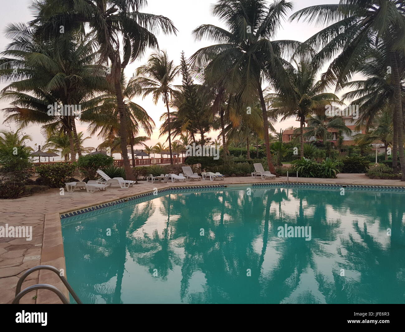 La fin de nuit avec le coucher du soleil, piscine d'Afrique de l'ouest à beach resort, Saly, Sénégal Banque D'Images