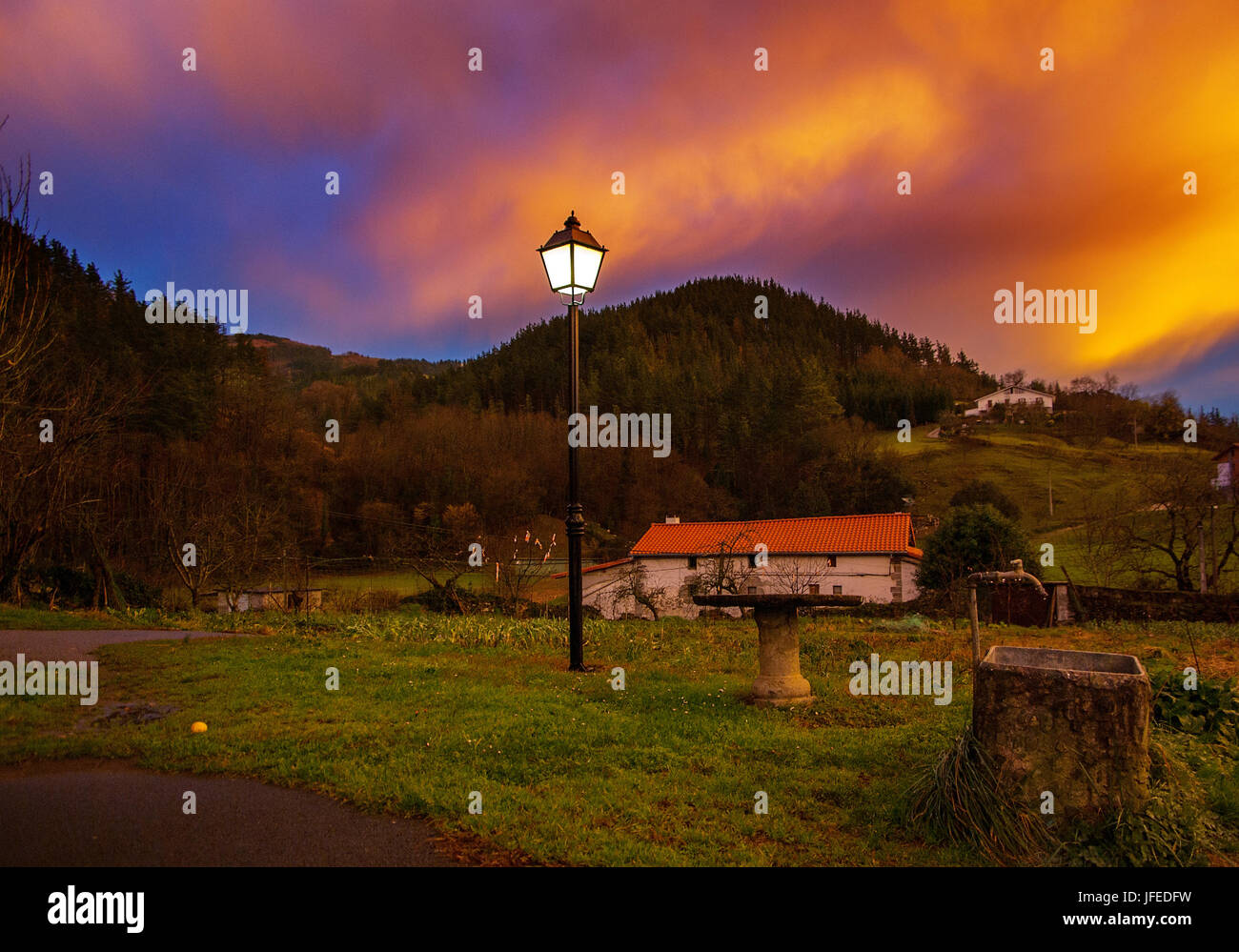 Ciel orange sur la ferme après la tempête à Urrestilla, Pays Basque, Espagne Banque D'Images