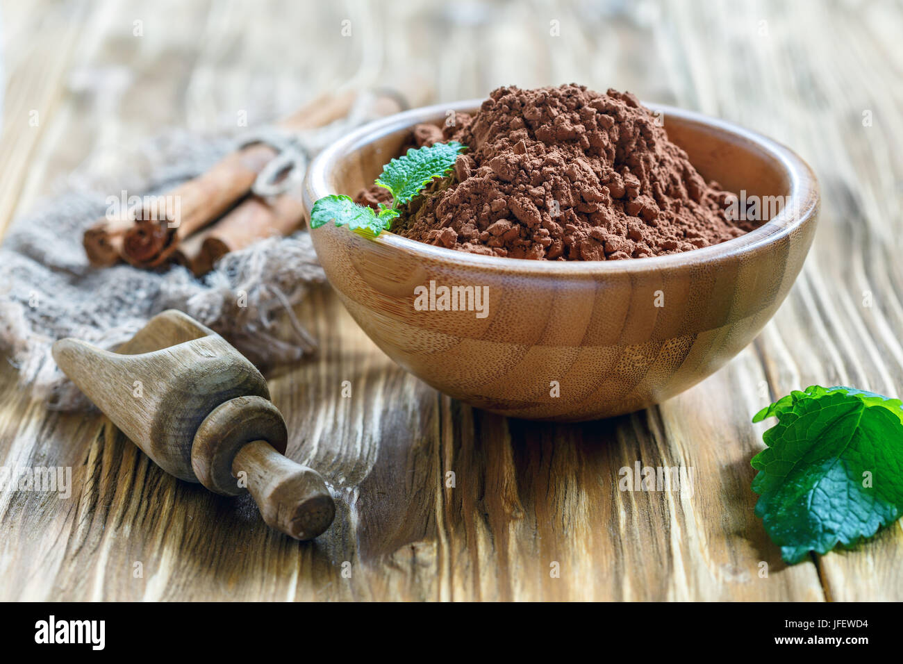 Bol de poudre de cacao et une cuillère en bois. Banque D'Images