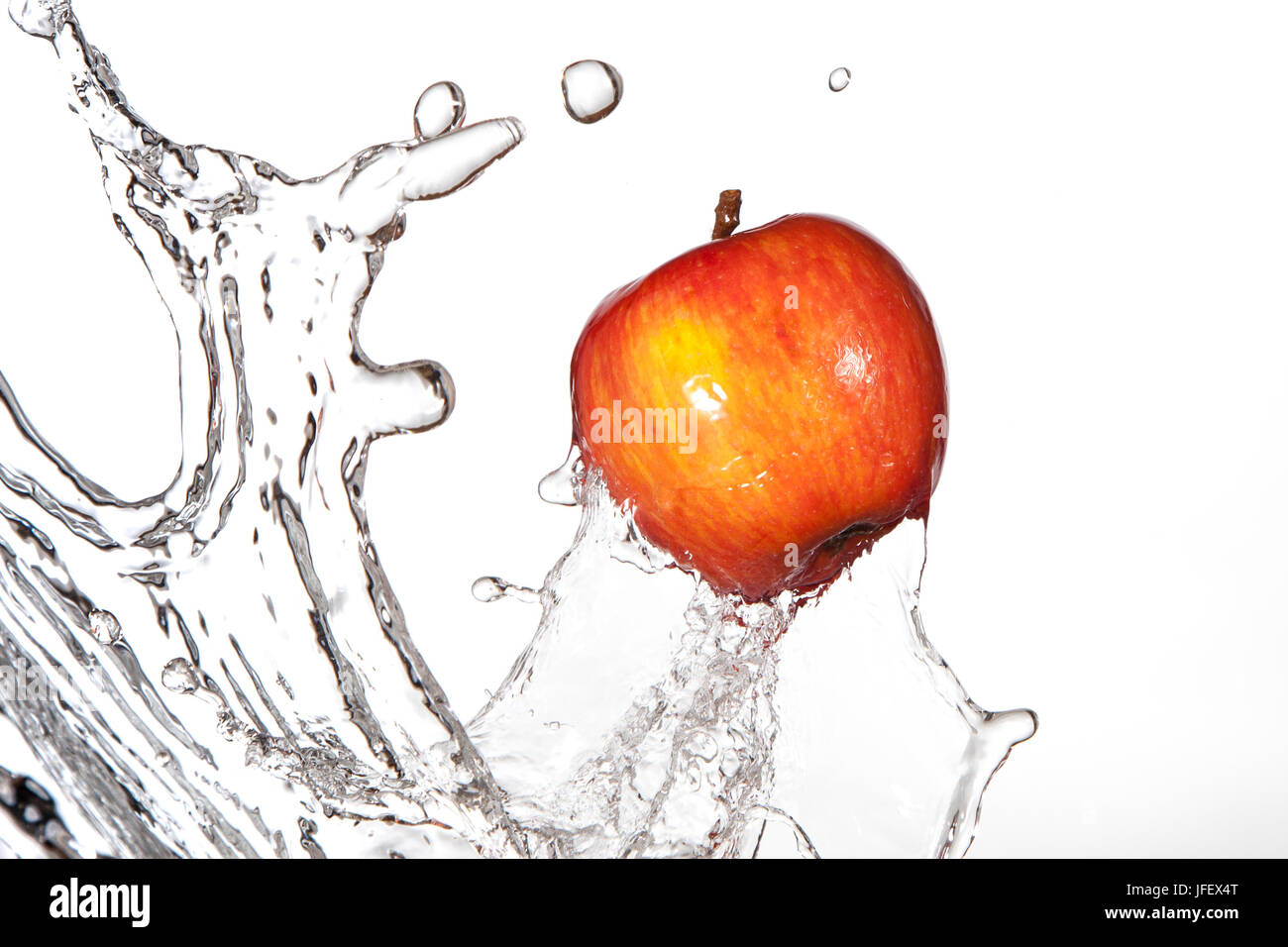 La pomme Red Delicious éclaboussant par l'eau douce. Banque D'Images