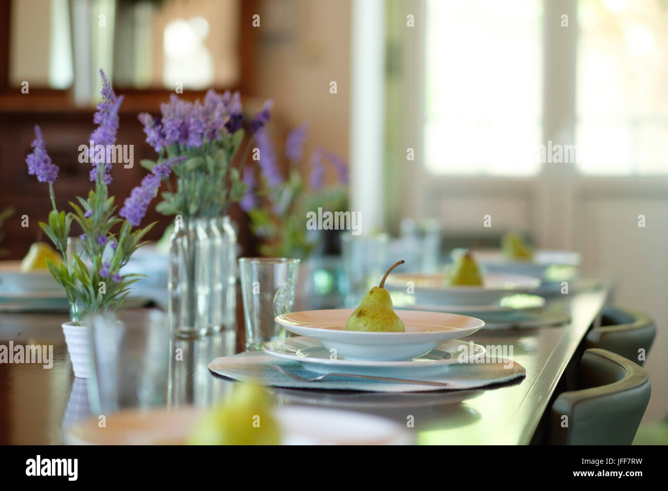 Selective focus photo d'une plaque avec une poire sur une table à manger Banque D'Images