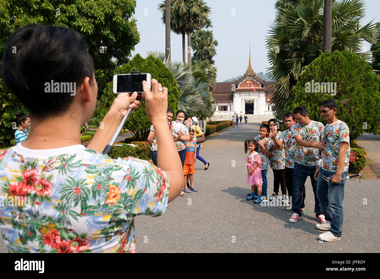 Famille en vacances qui pose pour photo de groupe sur le terrain du Palais Royal, Luang Prabang, Laos, Asie Banque D'Images