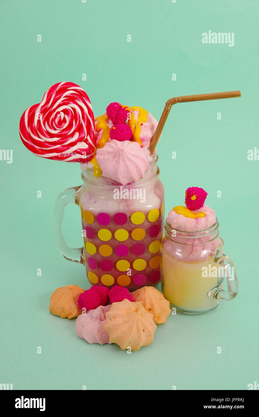 Maison délicieux lait frappé aux fraises de l'extrême dans un pot, avec un terminal blackberry candy sur une mousse de lait avec une paille en plastique et d'un blackberry rose candy Banque D'Images