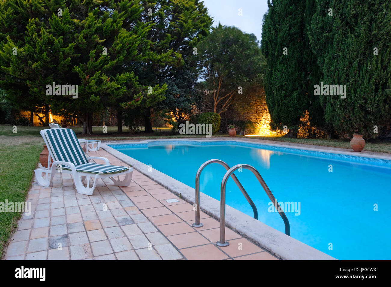 Une chaise à côté d'une piscine extérieure Banque D'Images