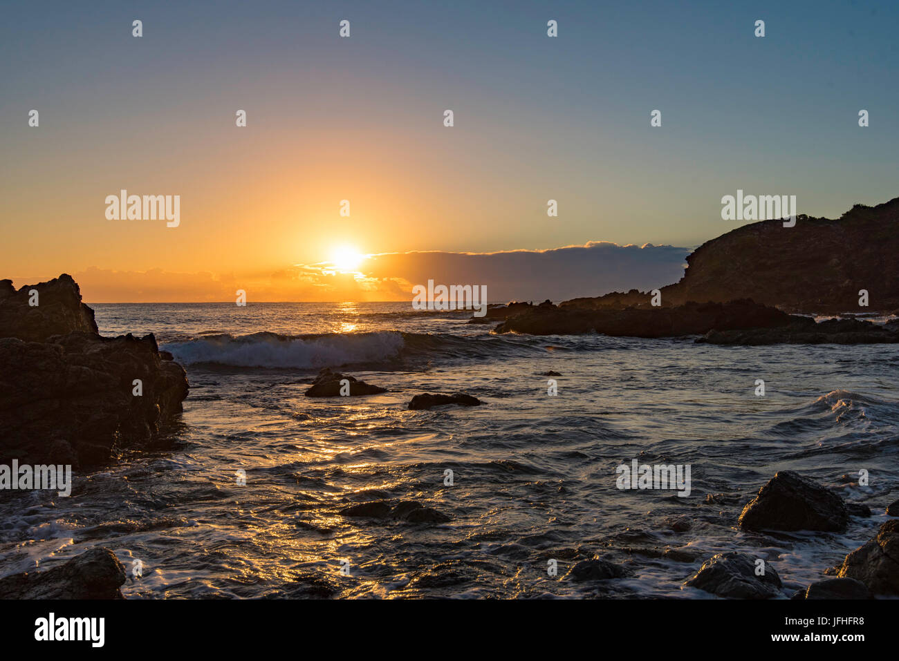 Le lever du soleil sur une plage de rochers sur la côte est de la Nouvelle-Galles du Sud, Australie Banque D'Images