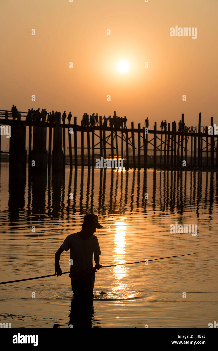 Amarapura, région de Mandalay, Myanmar, l'homme pêche au coucher du soleil en face de l'U Bein bridge, Banque D'Images