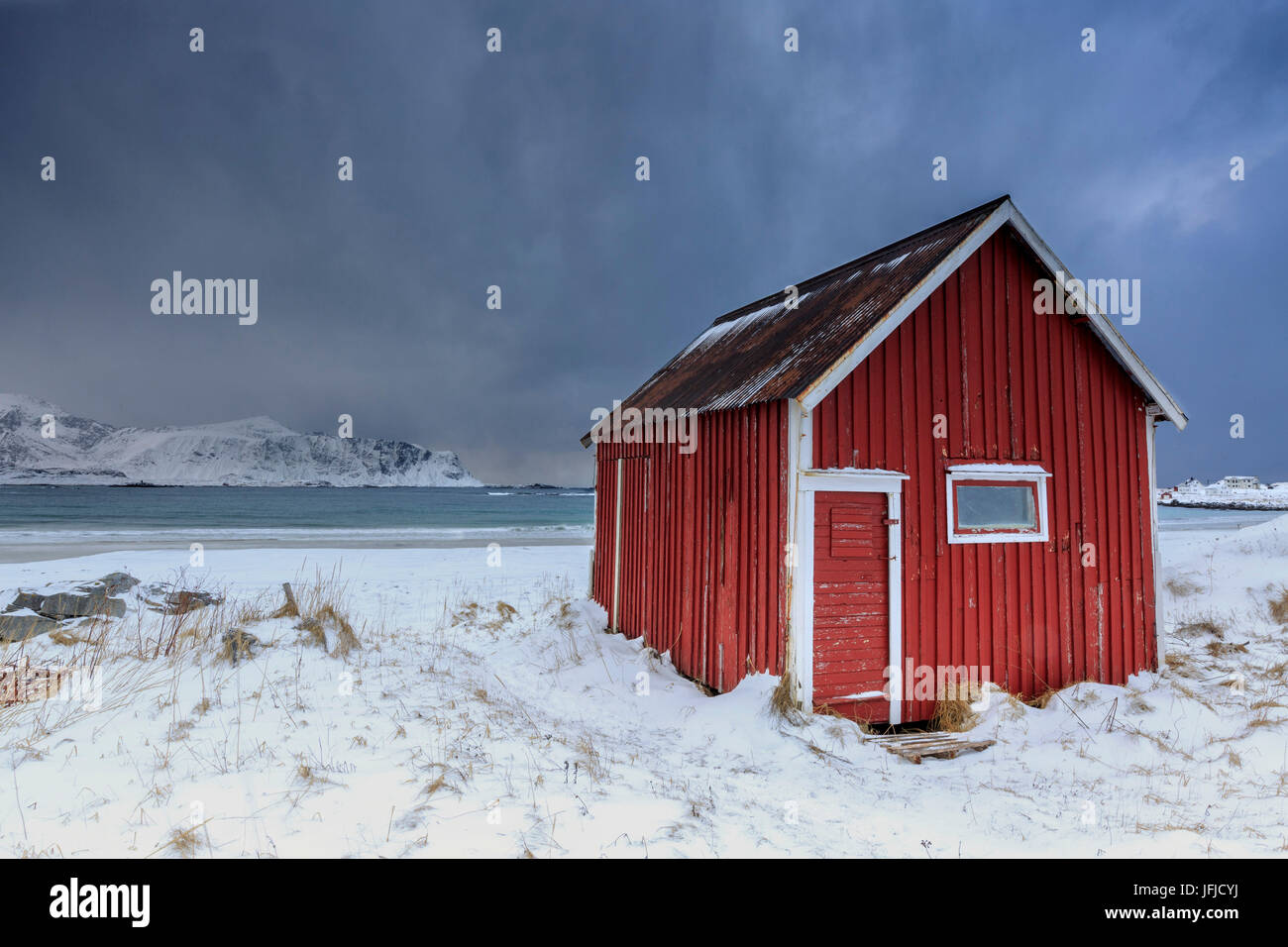 Une maison typique des pêcheurs appelée sur la plage enneigée rorbu cadres la mer glacée à Ramberg Lofoten, Norvège Europe Banque D'Images