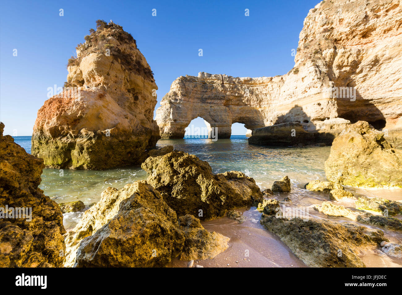 Lever du soleil sur les falaises et l'eau turquoise de l'océan Praia da Marinha Lagoa Caramujeira Municipalité Algarve Portugal Europe Banque D'Images