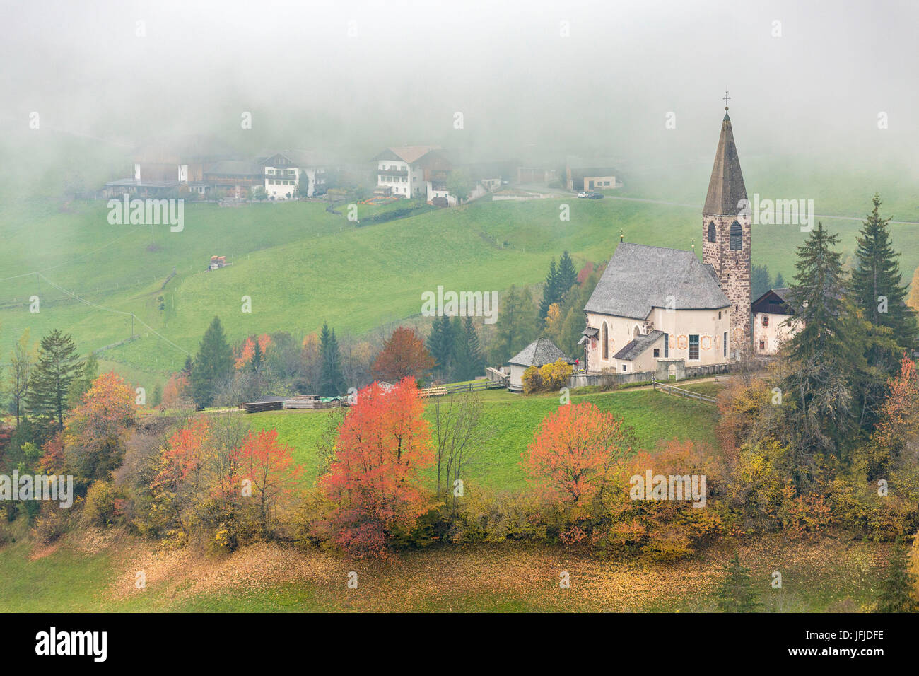 Église entourée par des arbres d'automne et de la brume, Santa Maddalena, Funes, Bolzano, Trentin-Haut-Adige - Sudtirol, Italie, Europe, Banque D'Images