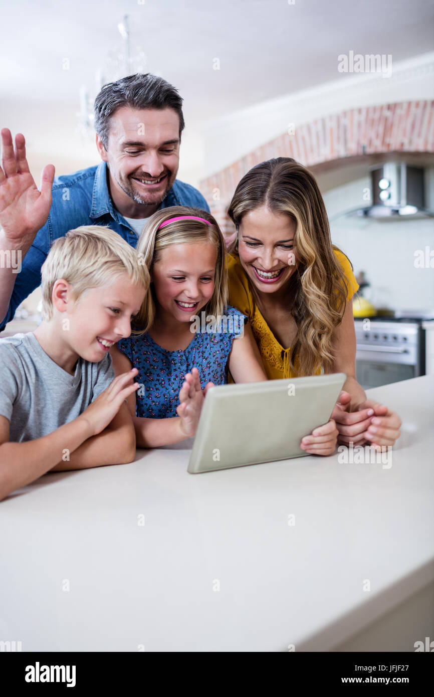 Parents et enfants using digital tablet in kitchen Banque D'Images