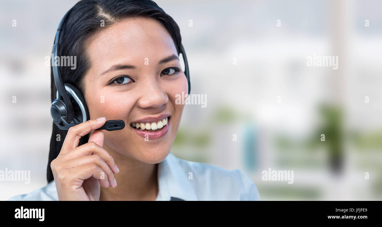Composite image of smiling businesswoman using headset Banque D'Images