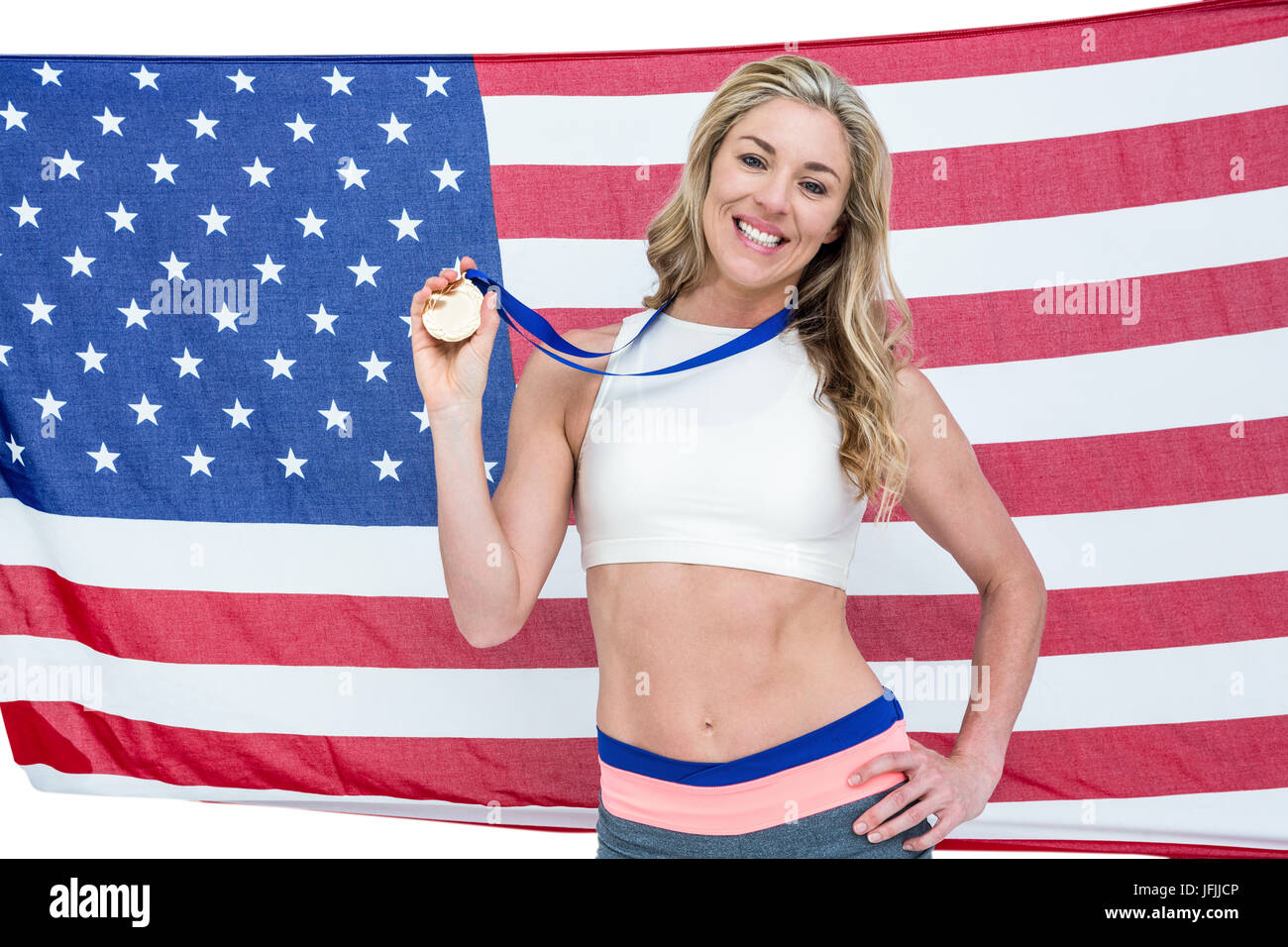 Athlète posant avec médailles d'or autour de son cou en avant du drapeau américain Banque D'Images