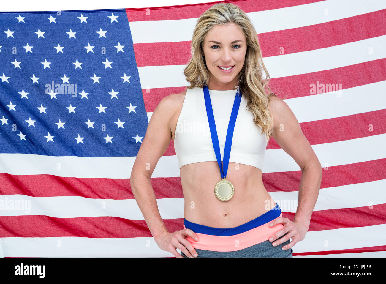 Athlète posant avec médailles d'or autour de son cou en avant du drapeau américain Banque D'Images