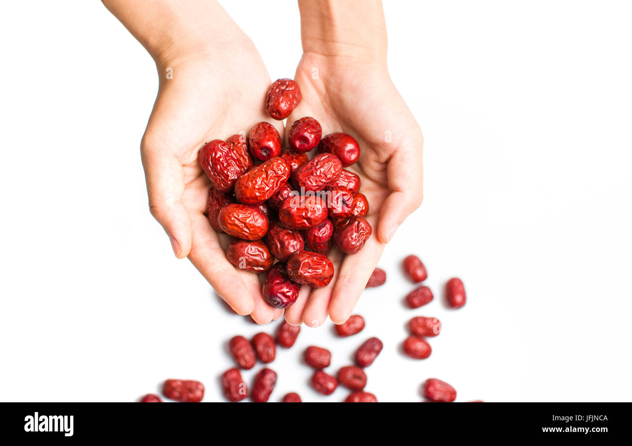 Hand holding red chinois isolés dates séchées Banque D'Images Hand holding red chinois isolés dates séchées Banque D'Images