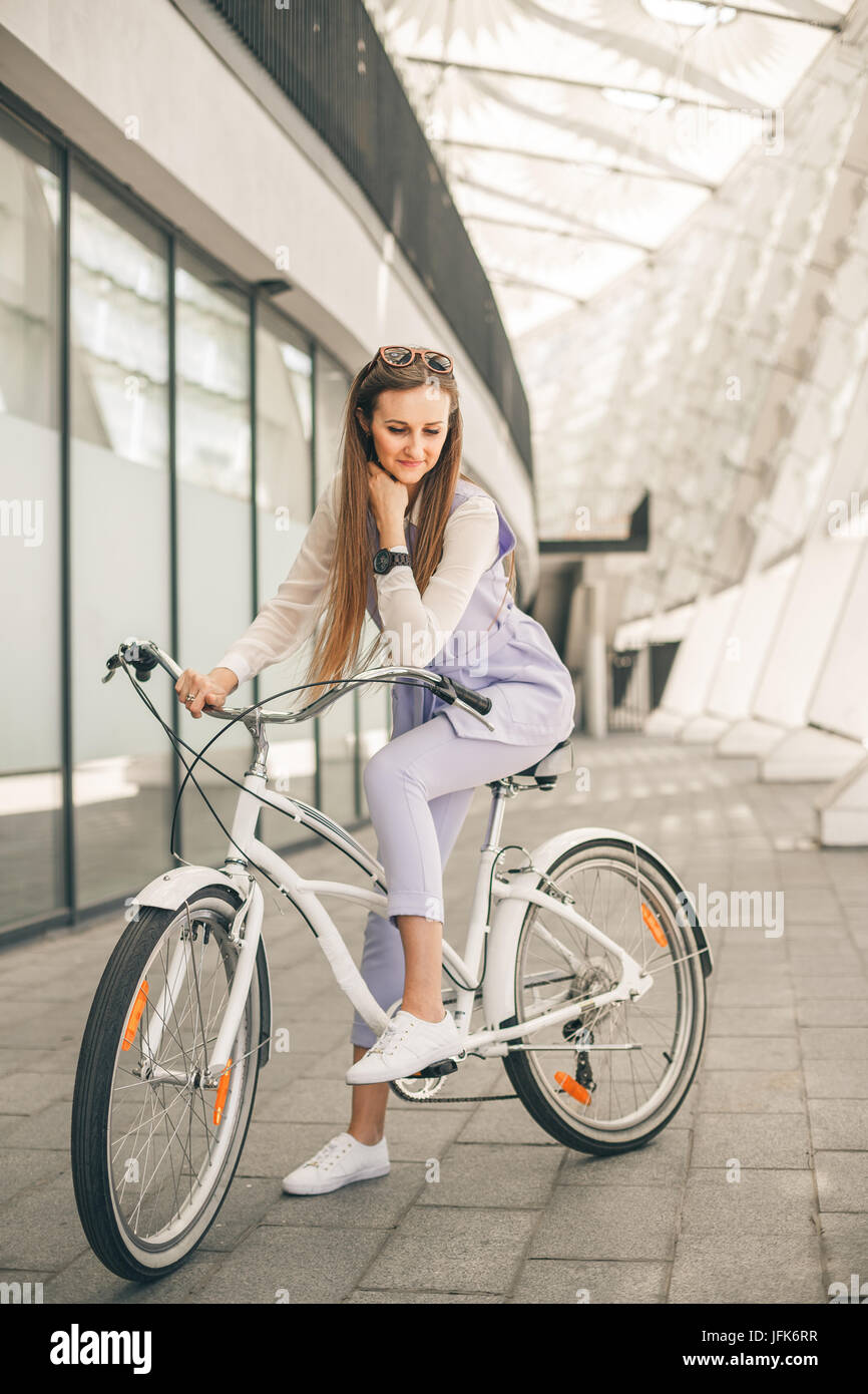 Tourné sur toute la longueur d'une belle jeune femme d'affaires avec son vélo Banque D'Images