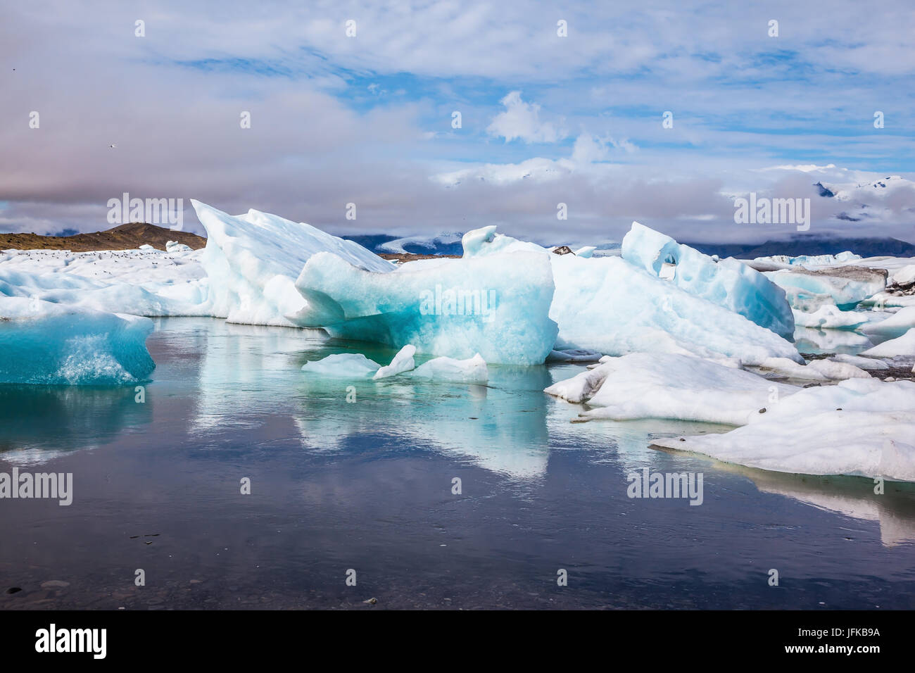 La glace flottante et les nuages reflètent dans l'eau lisse Banque D'Images