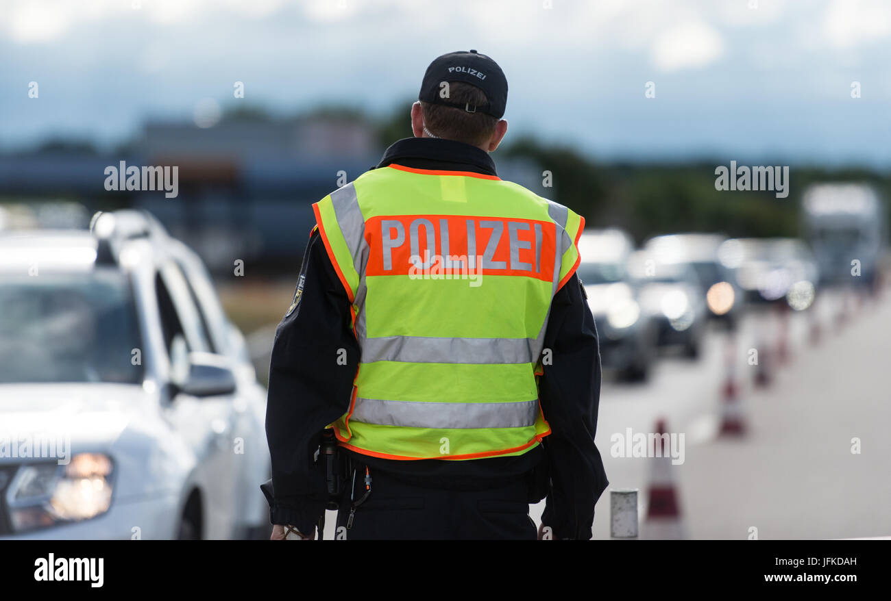Un officier de la Police fédérale inspecte le trafic automobile au passage de la frontière entre l'Allemagne et la Suisse à Weil am Rhein, Allemagne, 29 juin 2017. L'allemand a introduit des contrôles aux frontières pour un mois avant le Sommet du G20 à Hambourg. Photo : Patrick Seeger/dpa Banque D'Images