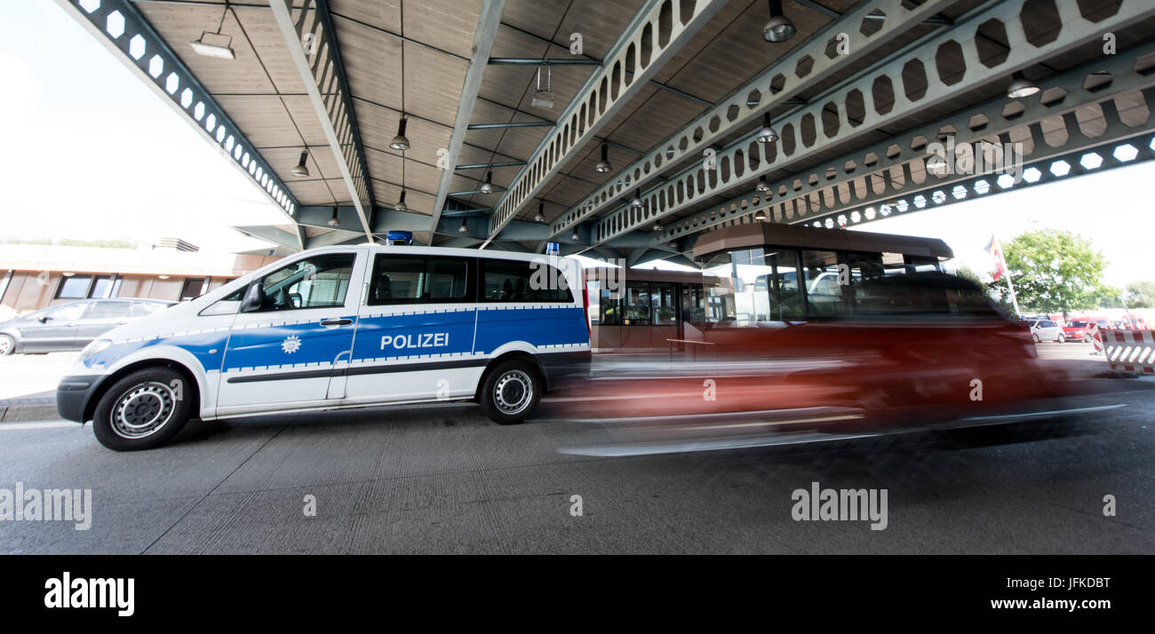 Une voiture passe par un véhicule de police au passage de la frontière entre l'Allemagne et la Suisse à Weil am Rhein, Allemagne, 29 juin 2017. L'allemand a introduit des contrôles aux frontières pour un mois avant le Sommet du G20 à Hambourg. Photo : Patrick Seeger/dpa Banque D'Images