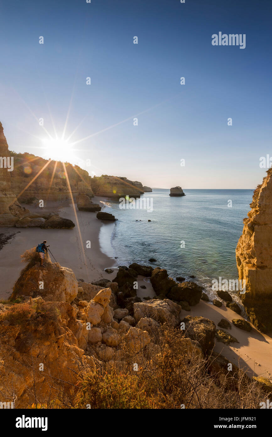 Premiers rayons de soleil sur les falaises et l'eau turquoise à Praia da Marinha Lagoa Caramujeira Municipalité Algarve Portugal Europe Banque D'Images