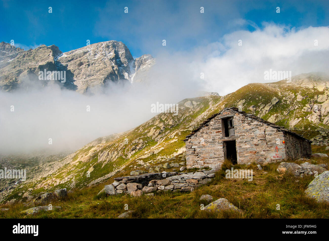 Un vieux chalet alpin, sous les pics sauvages et les nuages, (Piémont, Gran Paradiso National Park) Banque D'Images