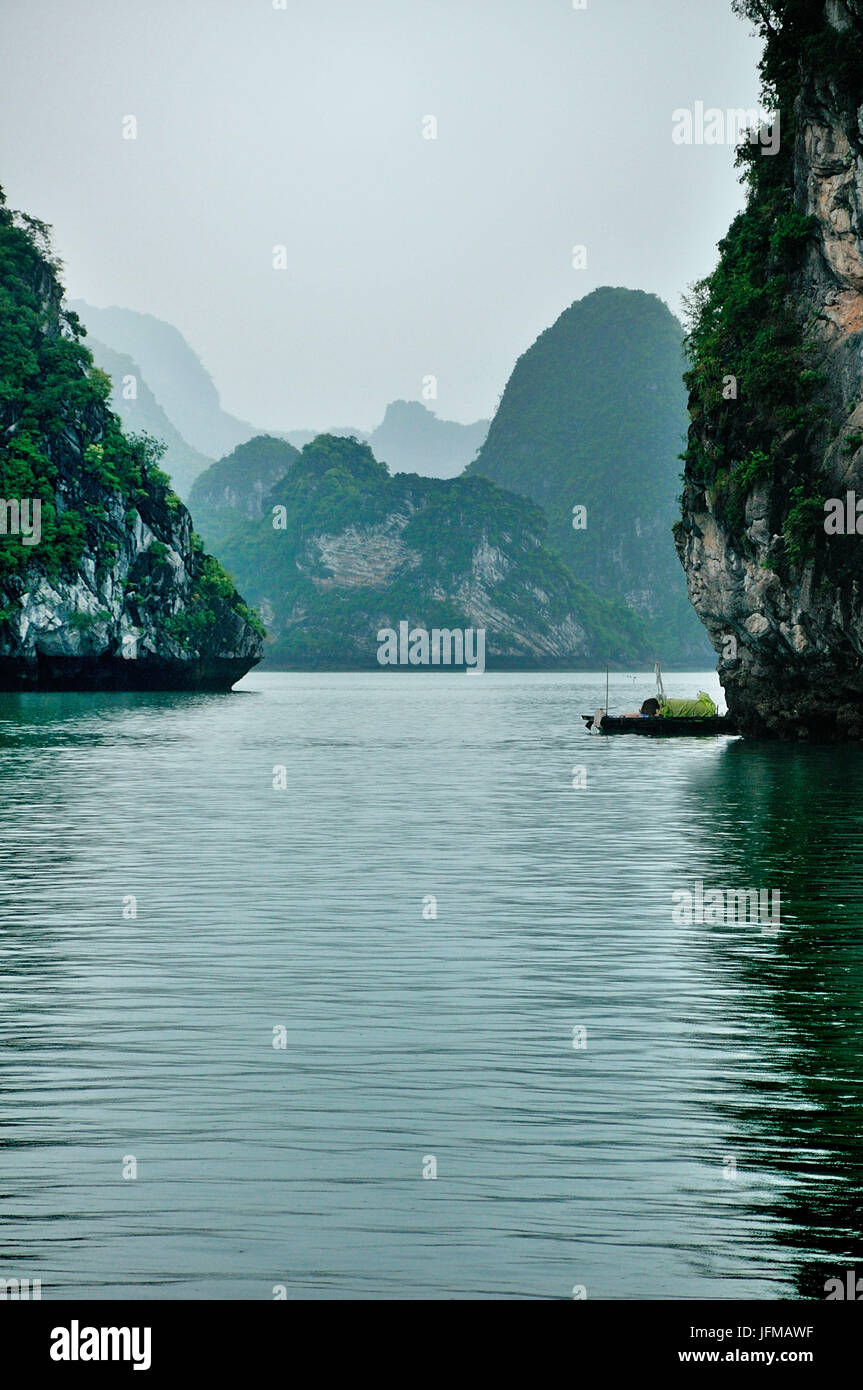 Vietnam, Ha Long Bay, vue sur des montagnes caractéristiques de la Baie d'Halong, avec un petit bateau typique Banque D'Images