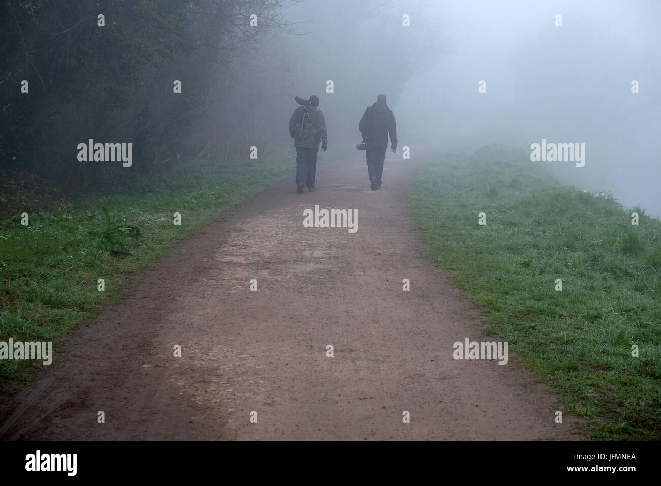 6 avril 2017 - Deux watchersheading brid au brouillard tôt le matin pour la journée au mur jambon réserve naturelle RSPB à Somerset Banque D'Images