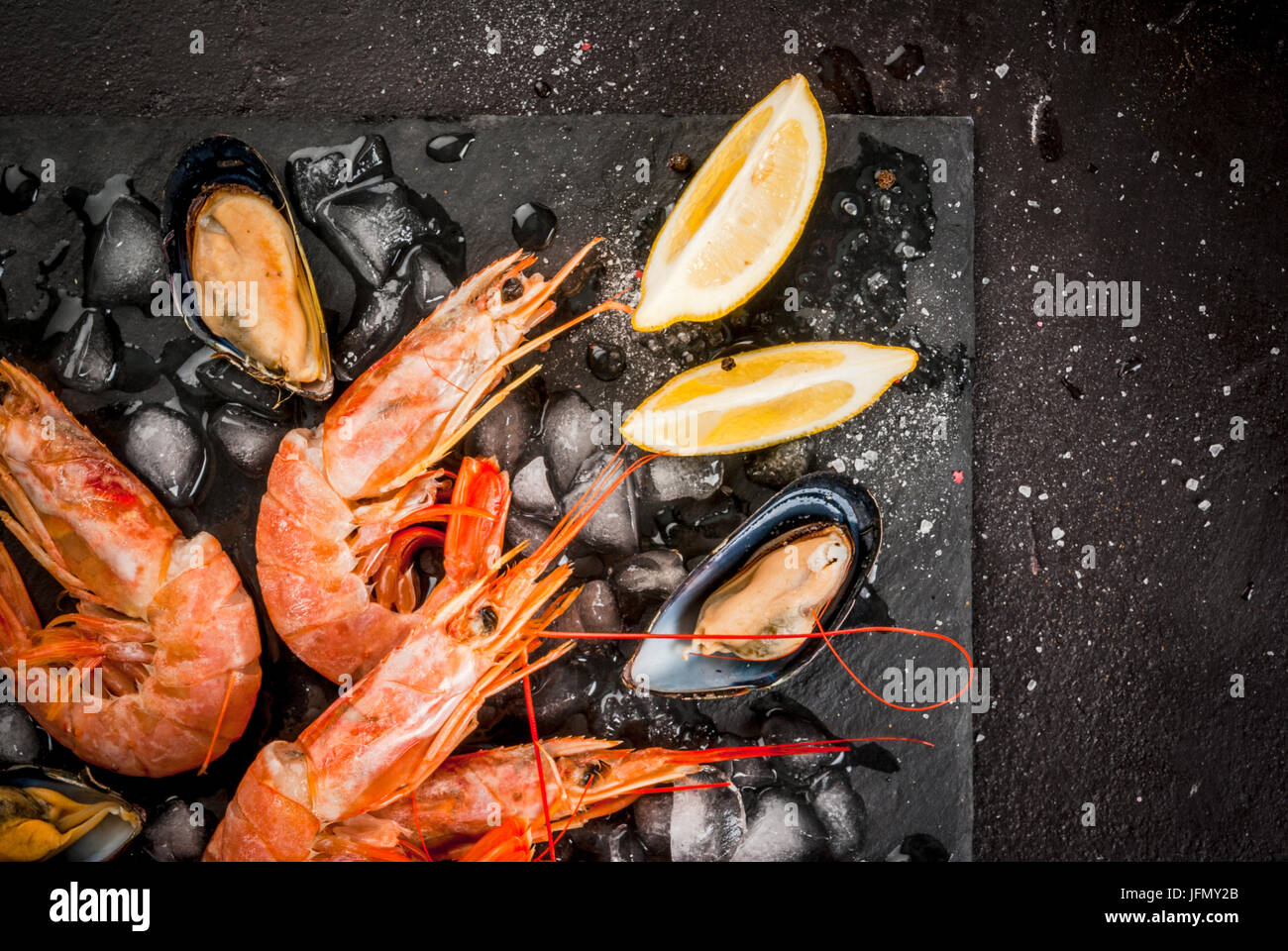 Préparé pour le dîner de cuisine fruits de mer - crevettes et moules sur la glace, sur une plaque en ardoise, coupe avec le citron et les épices. Vue de dessus, copy space Banque D'Images Préparé pour le dîner de cuisine fruits de mer - crevettes et moules sur la glace, sur une plaque en ardoise, coupe avec le citron et les épices. Vue de dessus, copy space Banque D'Images