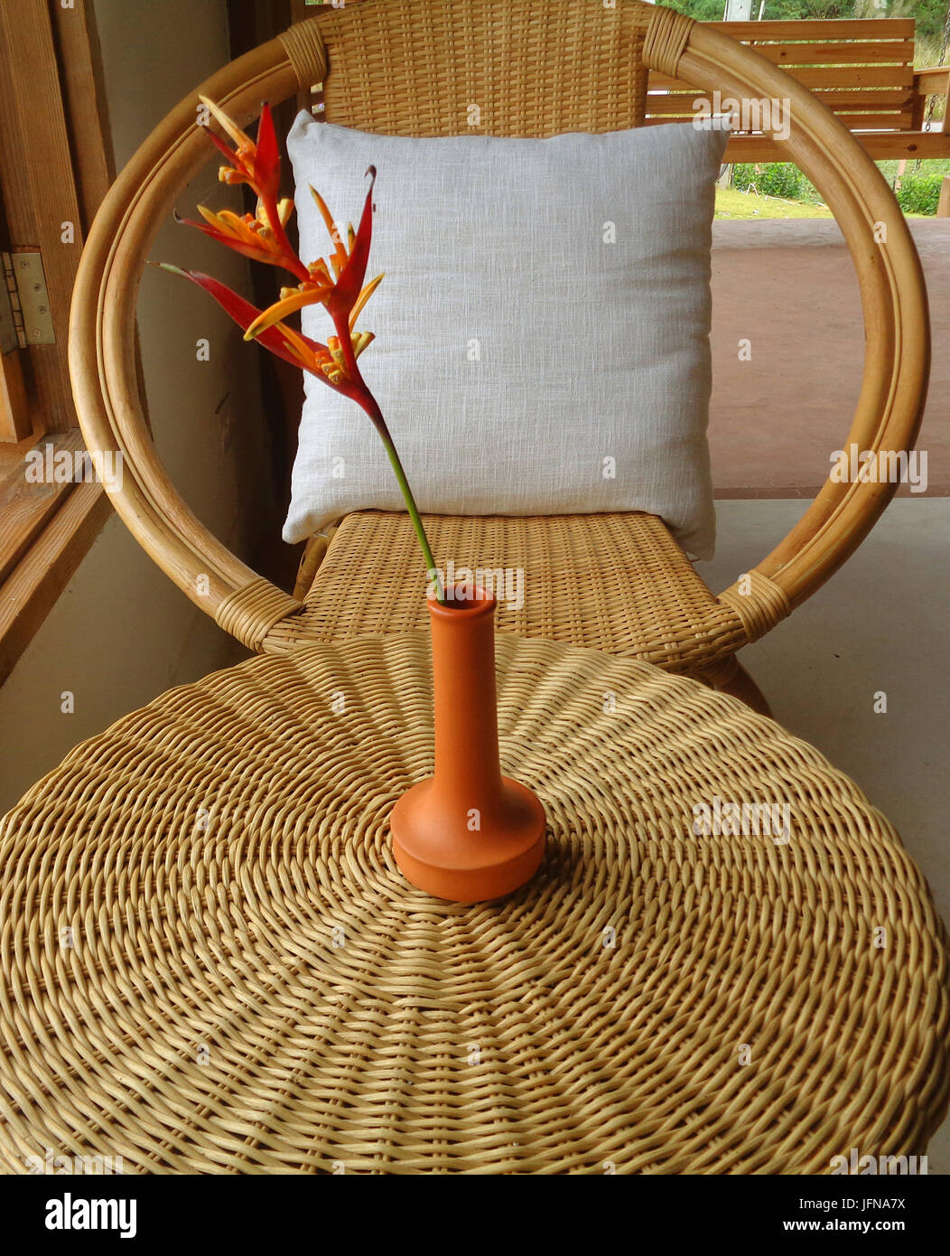 Couleur brun naturel canapé en rotin et table ronde avec vase à fleurs par la fenêtre Banque D'Images