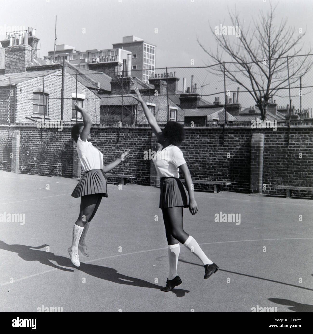 Deux jeunes filles noires, afro caraïbes jouer netball à Londres, en Angleterre, pendant les années 1970. Banque D'Images