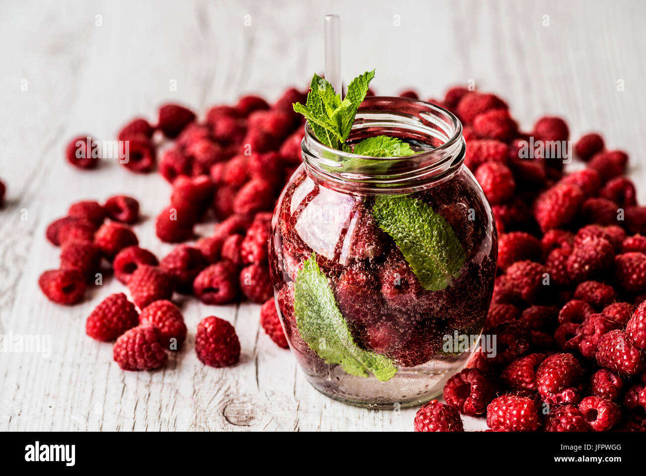 L'eau detox avec framboise sur fond de bois blanc. Des boissons saines Banque D'Images