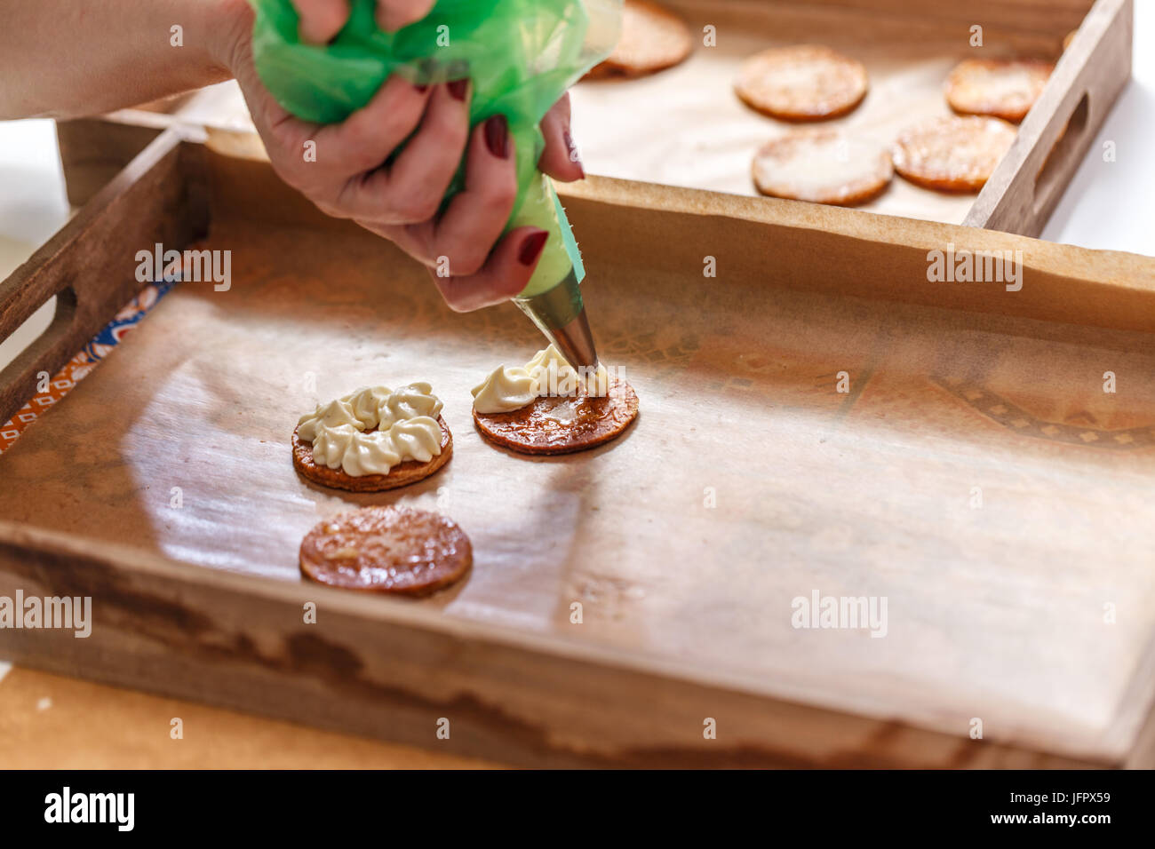 Chef pâtissier décoration d'un mille-feuille gâteau avec une crème fouettée Banque D'Images