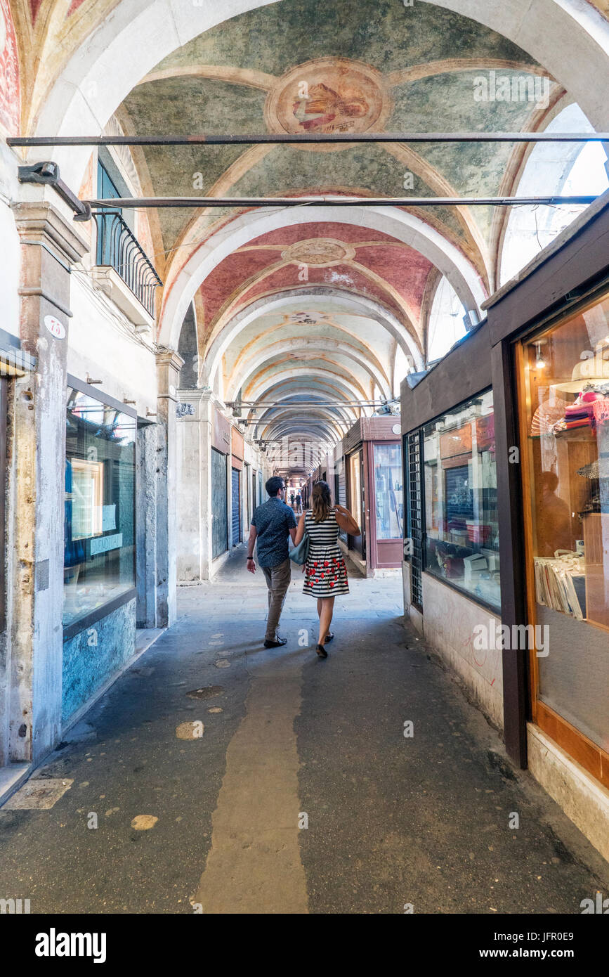 Pareja paseando por los Arcos de las casas de la calle Ruga del ''llamada' Oresi en Venecia, Italia Banque D'Images
