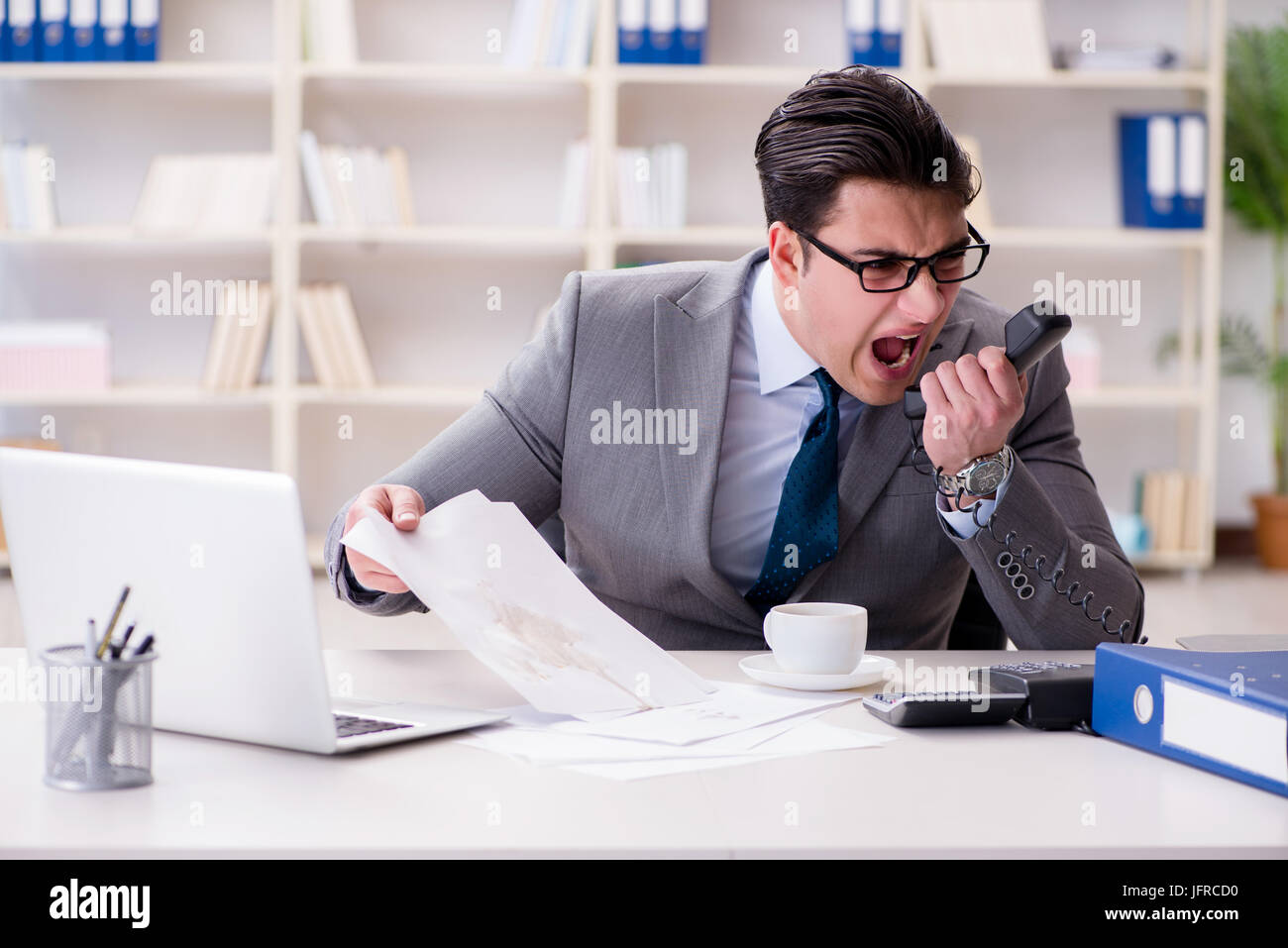 Businessman de renverser du café sur des documents importants Banque D'Images Businessman de renverser du café sur des documents importants Banque D'Images
