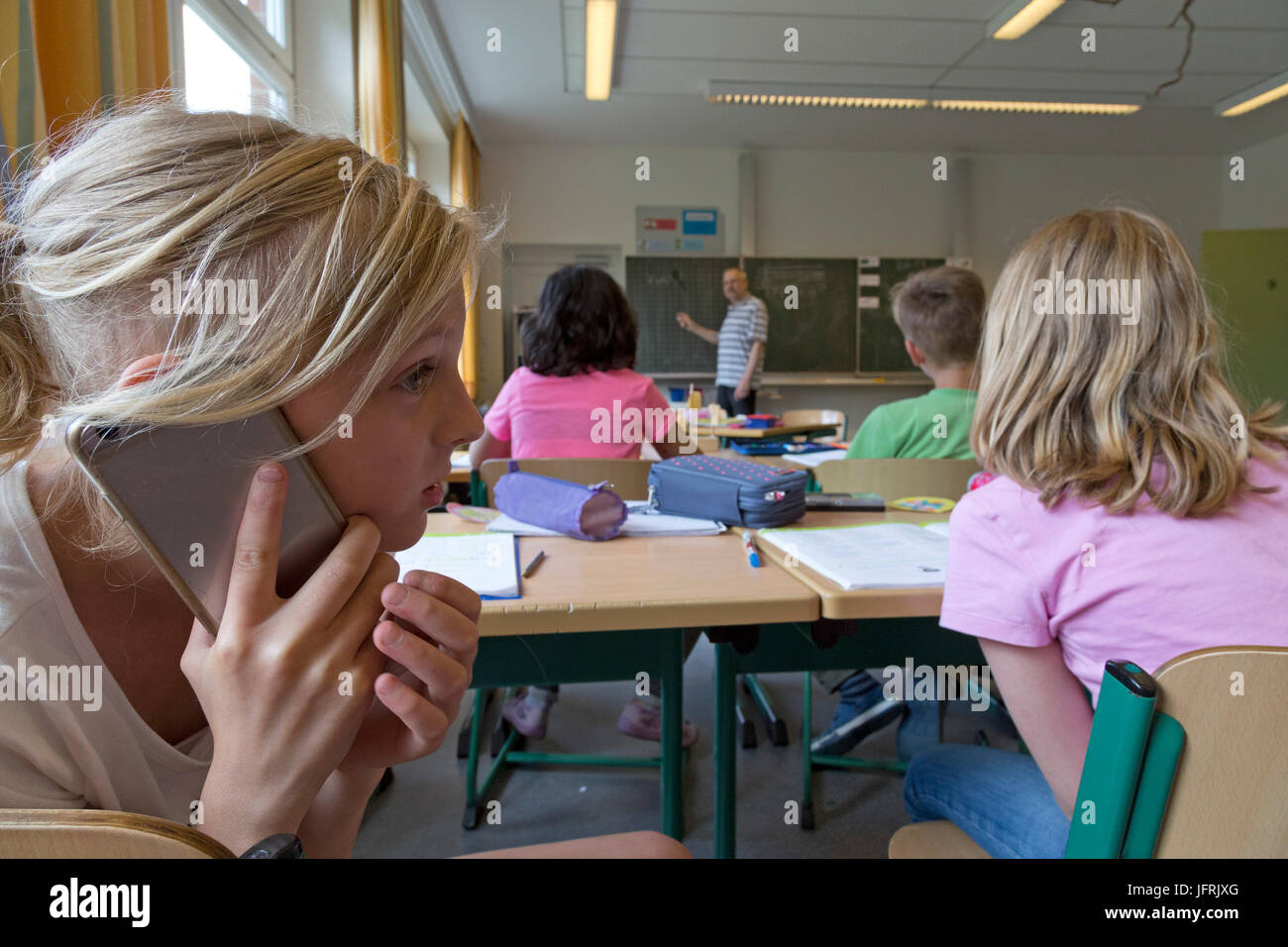 Fille de l'école primaire à l'aide de son téléphone portable pendant les cours Banque D'Images